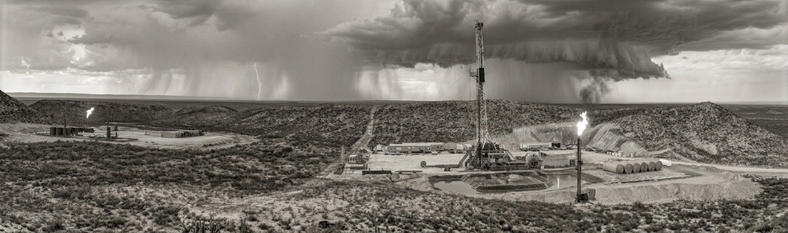 Black-and-white photograph of a drilling rig at a Texas oil and gas site
